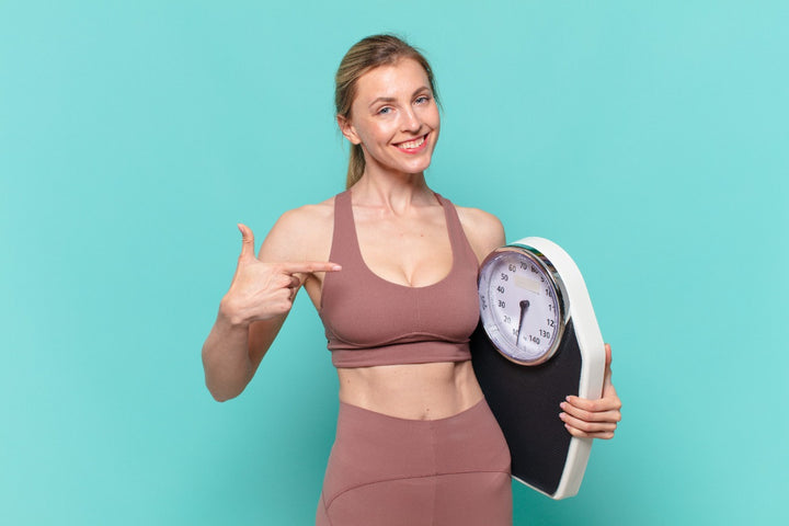 a woman pointing towards weight machine