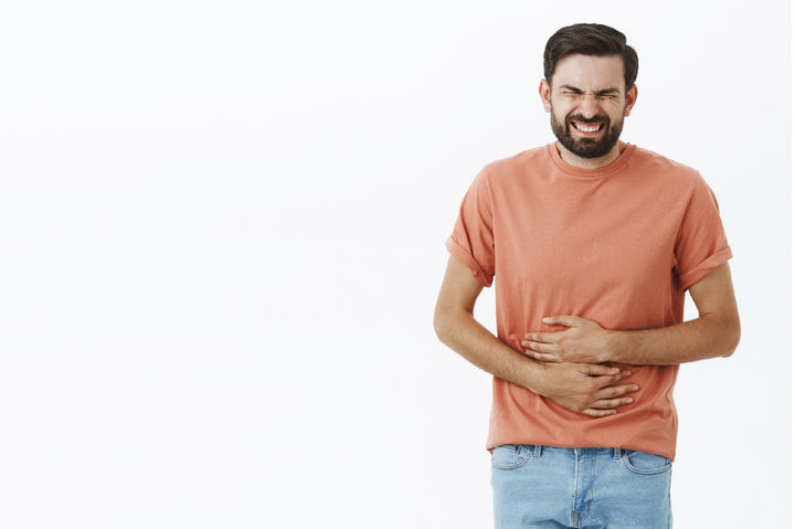 a man suffering from stomach ache and holding his stomach