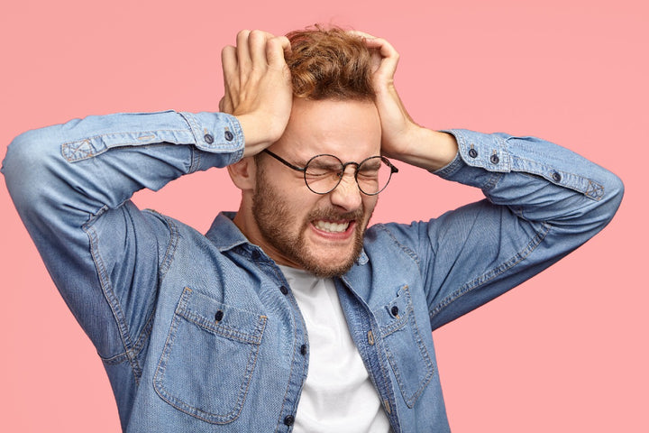 a man holding his head because he is stressed