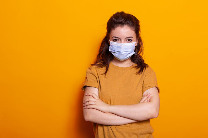 a woman wearing a face mask is standing