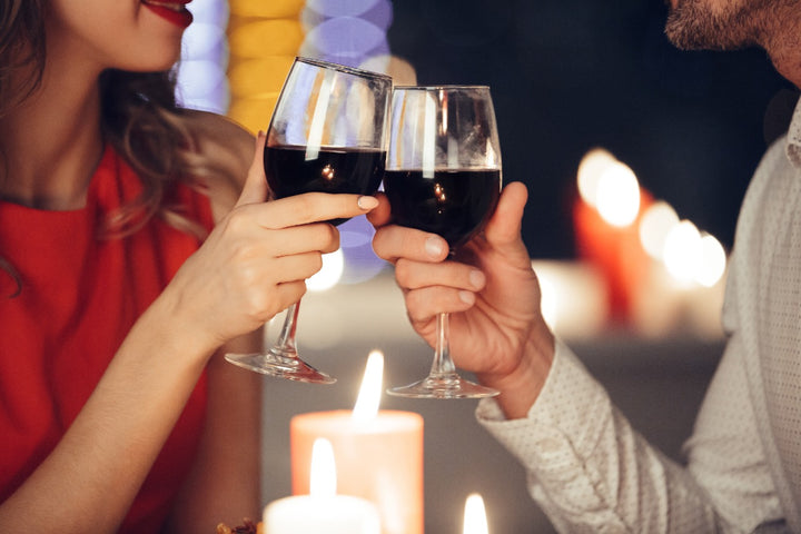 a couple holding beverages in glasses 