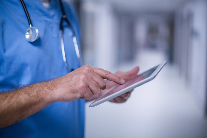 a doctor holding a tablet gadget in his hand