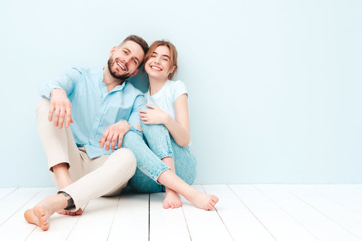 a couple sitting on the floor and laughing