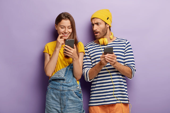 a man and a woman having fun while surfing on their phones