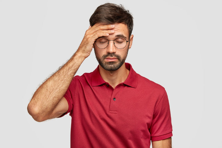 a man holding his head due to nausea